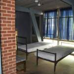 Downstairs view of a cabin, showing 2 of the beds and windows.