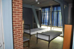 Downstairs view of a cabin, showing 2 of the beds and windows.